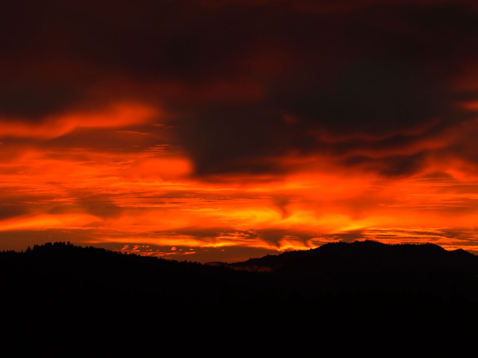 A molten orange and red sky above a dark ridge in Sonoma County